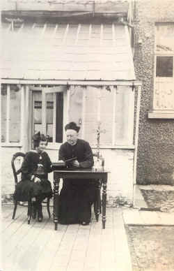 EH van Driessche met een kostschoolmeisje aan de serre